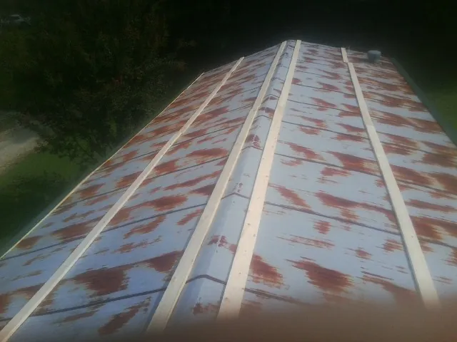 Rusted metal roof panels with new wood purlins before replacement — Storm Damage Roof Repair in Losantville by Roofing Brothers