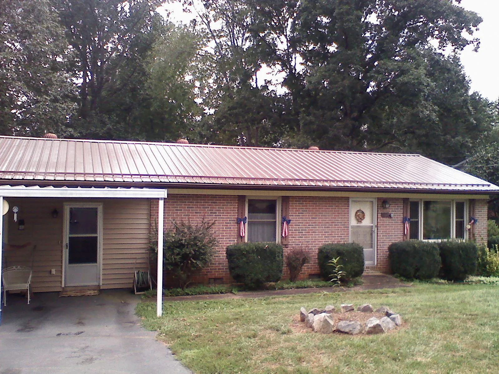 Bronze metal roof and carport on a brick ranch home — Roof Repair work by our crew in Losantville
